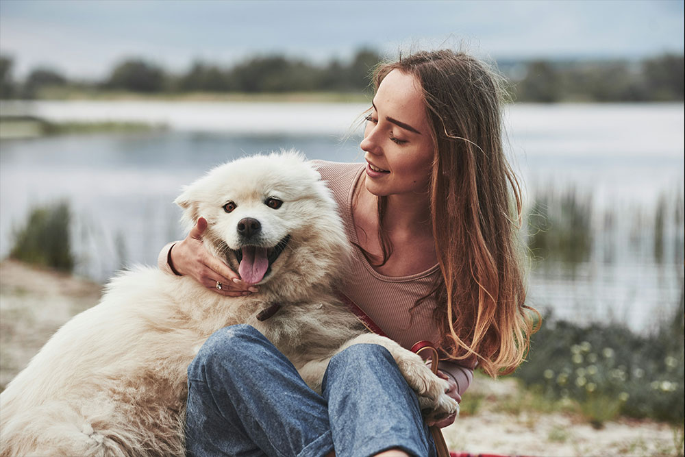 Girl and fluffy dog smiling