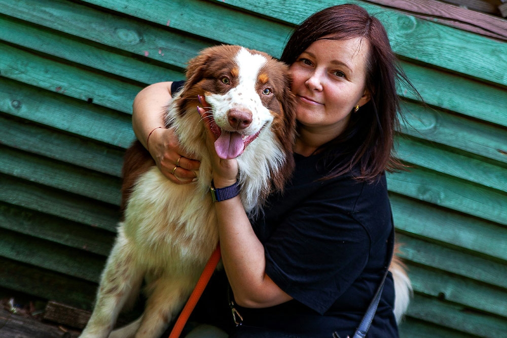 Woman hugging brown and white dog