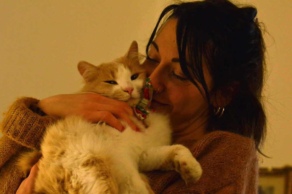 Woman lovingly holding ginger cat